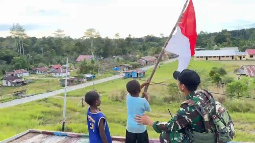 Prajurit TNI dari Satgas Yonif 642/Kapuas menyerahkan bendera Merah Putih kepada warga Kampung Yermatum di perbatasan Papua Barat dalam rangka HUT RI ke-80.