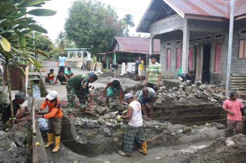 Warga dan personel TNI bekerja membangun drainase dan Jembatan Leger di Desa Ombawa, Halsel