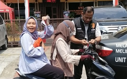 Kapolsek Kebon Jeruk membagikan bendera merah putih kepada pengendara motor di Jalan Raya Kebon Jeruk dalam rangka peringatan HUT RI ke-80.