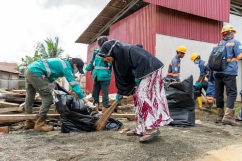 Karyawan Harita Nickel bersama masyarakat Kawasi melakukan aksi bersih sampah di jalan utama Desa Kawasi, Halmahera Selatan.