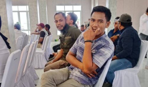 Ilham Lakoda duduk di kursi sambil memegang dagu saat berada di sebuah kegiatan bersama sejumlah Kepala Desa.