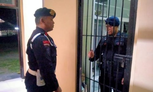 Seorang anggota Brimob Polda Maluku Utara terlihat berada di dalam ruang tahanan saat dijaga petugas di depan pintu besi.